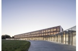 Les deux niveaux de salles de classe font figure de long parallélépipède de bois, posé sur un socle translucide qui s’incurve pour embrasser le paysage et la cour - Dietrich | Untertrifaller et Colas Durand - Crédit photo : BOEGLY Luc
